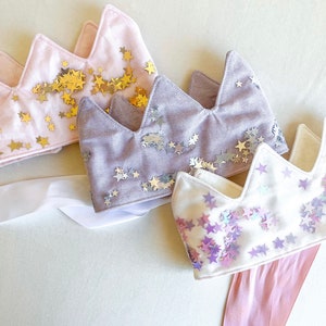 Our linen fabric shaker crowns come in three different colors, pink with gold stars, purple with silver stars and white with pink and purple stars. They are the perfect gift for any little princess, allowing her imagination to run wild.