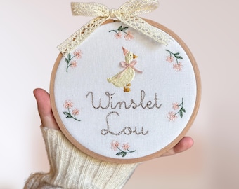 Embroidered plaque with baby’s name, nursery rhyme goose and a minimalist floral wreath | baby name announcement sign and nursery wall decor