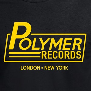 Könnte beinhalten: Schwarzes T-Shirt mit einer gelben Grafik des Textes "Polymer Records" im Retro-Stil mit den Worten "London - New York" darunter.