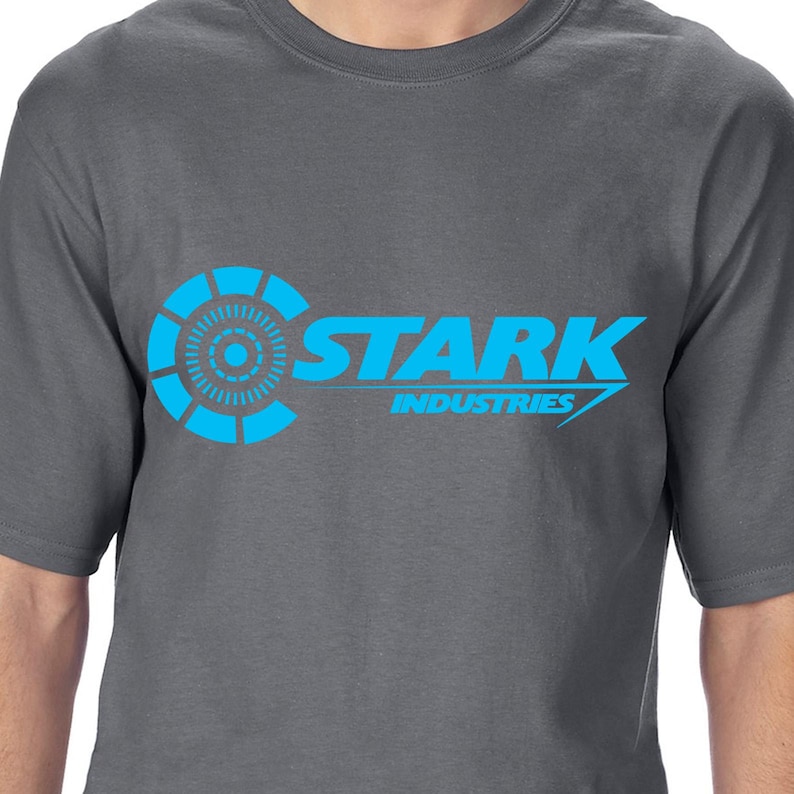 May include: A gray t-shirt with a blue Stark Industries logo. The logo features a circular design with a smaller circle in the center and the text "Stark Industries" in a stylized font.