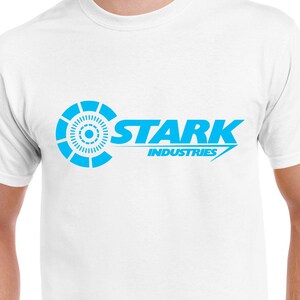 May include: White t-shirt with a blue Stark Industries logo. The logo features a stylized circle with a smaller circle inside and the text "Stark Industries" in a bold, sans-serif font.