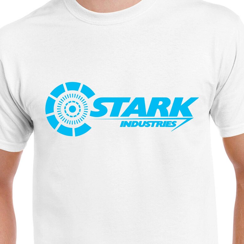 May include: White t-shirt with a blue Stark Industries logo. The logo features a stylized circle with a smaller circle inside and the text "Stark Industries" in a bold, sans-serif font.