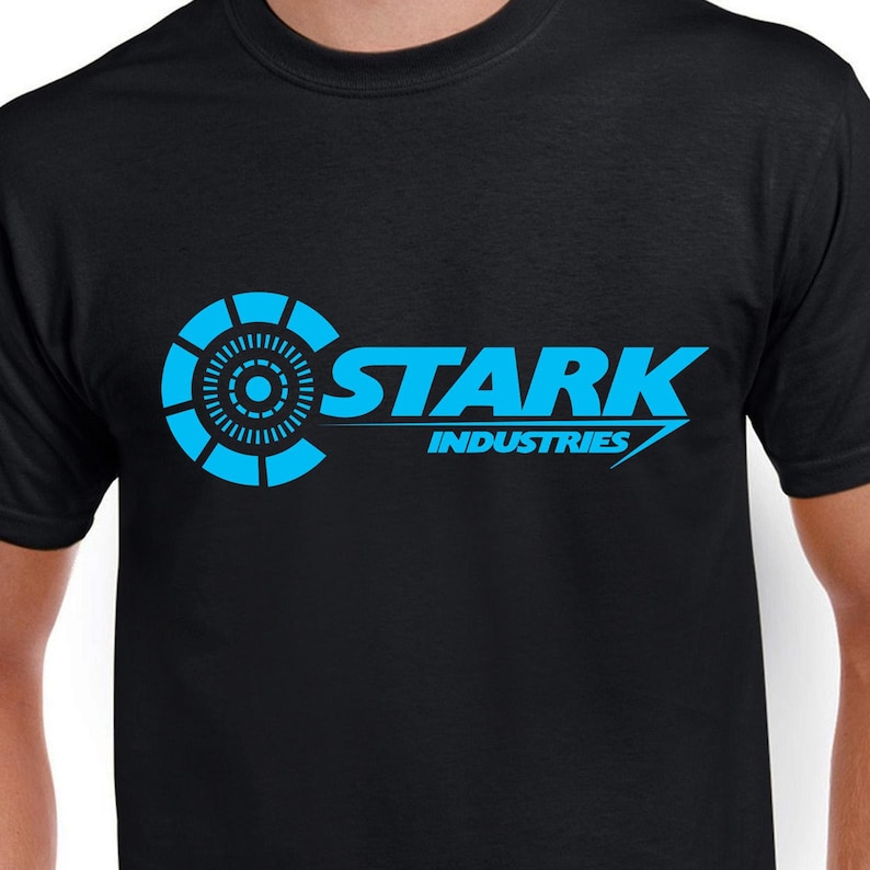 May include: Black t-shirt with a blue Stark Industries logo. The logo features a circular design with a smaller circle in the center and the text "Stark Industries" in a bold, sans-serif font.
