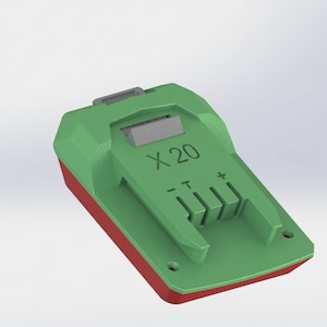Può includere: Caricabatterie verde e rosso con la scritta "X20" sul davanti. Il caricabatterie ha uno slot per una batteria e una serie di contatti metallici.