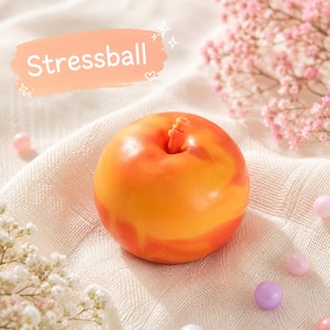 Könnte beinhalten: Ein runder, glatter Stressball in Apfelform mit einem marmorierten orange-roten Farbmuster und einem kleinen Stiel an der Oberseite. Das Wort Stressball ist in weißer Schrift auf einer hellorangen rechteckigen Grafik über dem Objekt abgebildet.