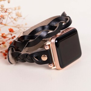 May include: Black leather braided watch band with rose gold accents for an Apple Watch.