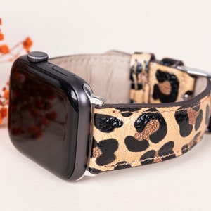 Op de afbeelding: Een zwarte smartwatch met een gouden luipaardprint lederen band.
