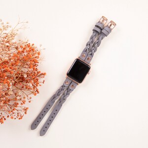 Peut inclure: Un bracelet de montre en cuir tress&eacute; gris avec des d&eacute;tails en or rose. Le bracelet est con&ccedil;u pour une Apple Watch.