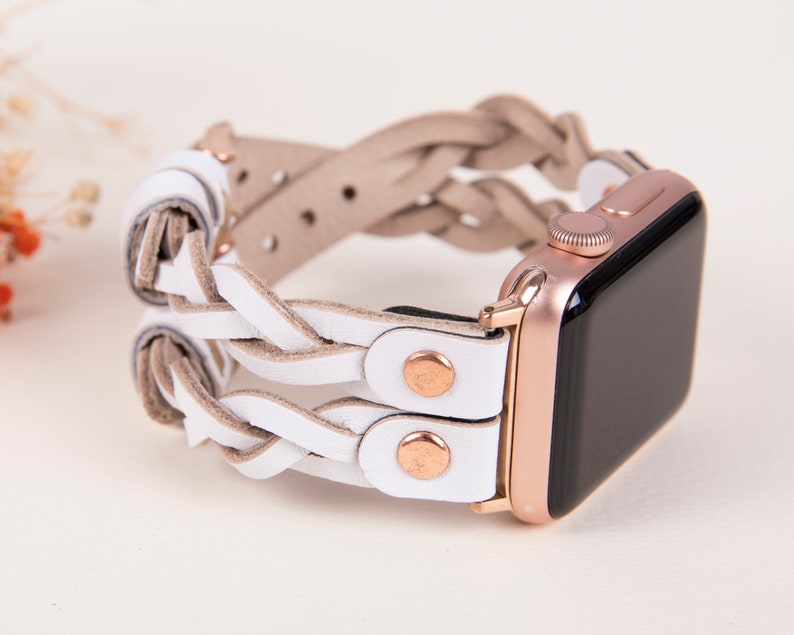 Peut inclure: Bracelet de montre Apple en cuir tress&eacute; blanc avec des d&eacute;tails en or rose. Le bracelet est double et pr&eacute;sente un design tiss&eacute;.