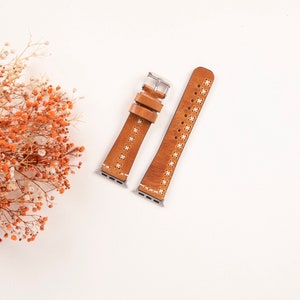 May include: Two brown leather watch bands with white stitching and silver hardware. The bands are on a white background.