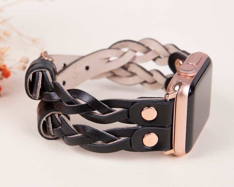 Peut inclure: Un bracelet de montre Apple en cuir noir tress&eacute; avec des d&eacute;tails en or rose. Le bracelet est double et pr&eacute;sente un design tiss&eacute;.