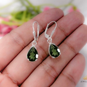 Peut inclure: Une paire de boucles d'oreilles pendantes en argent avec des pierres précieuses vertes en forme de poire.