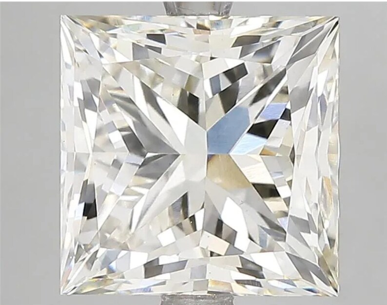 May include: A clear, square-shaped diamond with a brilliant cut. The diamond is set in a prong setting and has a high level of clarity.