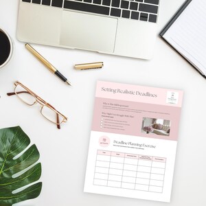 May include: A workspace setup with a laptop, gold pen, and glasses. A document titled "Setting Realistic Deadlines" is present, with a planning exercise table. A cup of coffee and a notebook are also visible on the white surface.