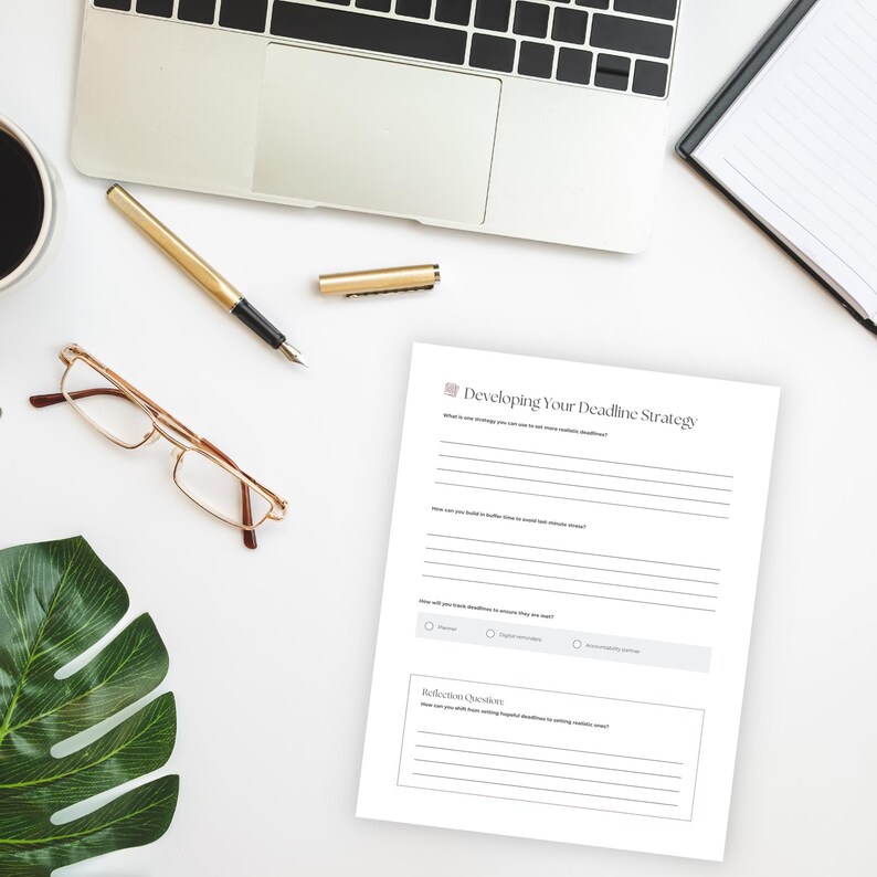 Peut inclure: Sc&egrave;ne de bureau avec un ordinateur portable, un stylo dor&eacute; et une feuille de papier intitul&eacute;e "Developing Your Deadline Strategy". On y trouve &eacute;galement une paire de lunettes, une tasse de caf&eacute; et un bloc-notes.