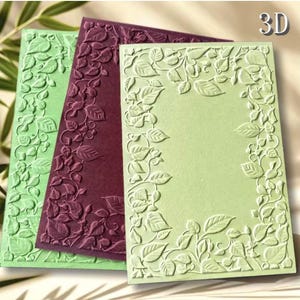 May include: Three rectangular cards featuring a 3D embossed leaf and vine border pattern. The cards are colored in light green, dark purple, and a pale mint green. Each card has a smooth, flat center area surrounded by the raised botanical design.