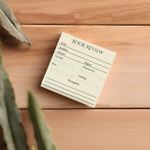 May include: A beige book review template with blank lines for title, author, genre, overall rating, plot, pages, characters, ending, and thoughts. The rating section has five stars for each category.