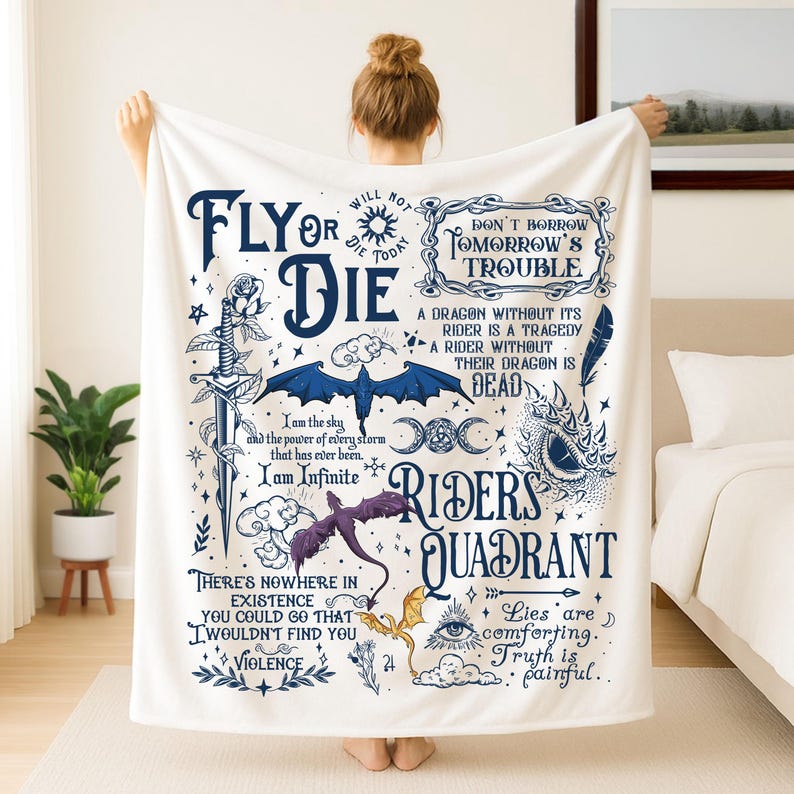 Op de afbeelding: Witte fleece deken met een fantasiethema. De deken heeft een blauwe draak, zwaard en tekst die luidt "Fly or Die" en "Riders Quadrant". Het ontwerp bevat andere illustraties en citaten in donkerblauw.