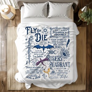 Op de afbeelding: Wit sprei met een donkerblauw en wit grafisch ontwerp met tekst en illustraties. De tekst bevat zinnen als "Fly or Die" en "Riders Quadrant". Illustraties zijn onder meer een zwaard, draken en sterren.