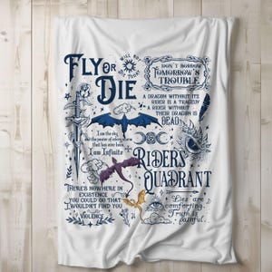 Op de afbeelding: Witte sprei met een fantasiethema. De sprei toont verschillende illustraties, waaronder draken, zwaarden en hemelse elementen, samen met verschillende citaten en zinnen in een gestileerd lettertype. Het kleurenpalet omvat tinten blauw, paars en goud.