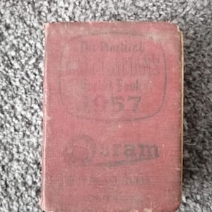 Puede incluir: Un libro rojo con el título "The Prudential Insurance Book 1937" y el logotipo "J.S. Bram" impreso en la portada.