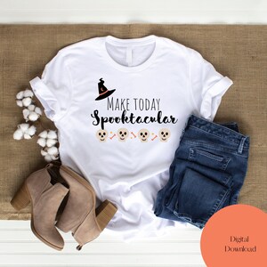 May include: White t-shirt with the text "Make Today Spooktacular" in black lettering. A witch's hat with a crescent moon is above the text. Five white skulls with black eyes and crossbones are below the text.