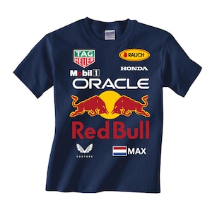 Peut inclure: Un t-shirt bleu marine avec le logo de l'&eacute;quipe de course Red Bull Racing. Le t-shirt pr&eacute;sente le logo Red Bull, les sponsors de l'&eacute;quipe et le nom du pilote, Max.