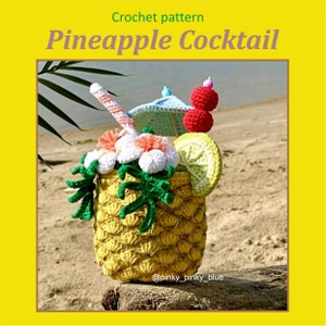 May include: Crochet pineapple cocktail pattern. A yellow pineapple-shaped crocheted cup with green leaves, a white flower, a red cherry, a yellow lemon slice, and a blue and white umbrella.
