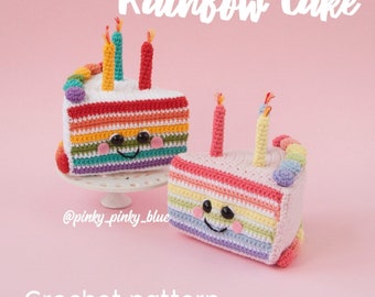 Op de afbeelding: Twee gebreide regenboogtaartpunten met lachende gezichten en kaarsen. De taartpunten staan op een wit voetstuk en een roze achtergrond. De tekst "Rainbow Cake" en "Crochet pattern" staat bovenaan en onderaan de afbeelding. De tekst "@pinky_pinky_blue" staat linksonder.