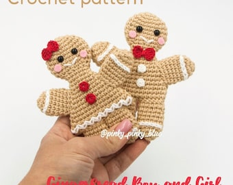 May include: Crochet pattern for a gingerbread boy and girl. The boy is wearing a red bow tie and the girl has a red bow on her head. Both are made with brown yarn and have white accents.