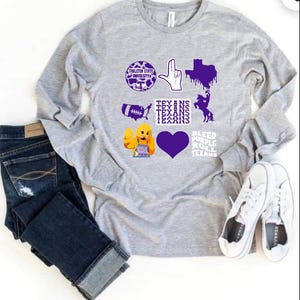 May include: A light gray long-sleeve shirt with various purple graphics, including a university logo, hand gesture, Texas outline, football, and a heart. The text "TEXANS" and "BLEED PURPLE ROLL TEXANS" are also present. Dark blue jeans and white sneakers are also in the image.