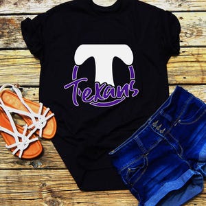 May include: Black t-shirt with a white "T" inside a purple circle and the word "Texans" in purple lettering.