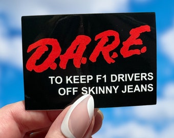 May include: A black sticker with the word "DARE" in red letters and the text "TO KEEP F1 DRIVERS OFF SKINNY JEANS" in white letters.