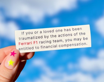 May include: A rectangular white card with black text and red text that reads: "If you or a loved one has been traumatized by the actions of the Ferrari F1 racing team, you may be entitled to financial compensation."