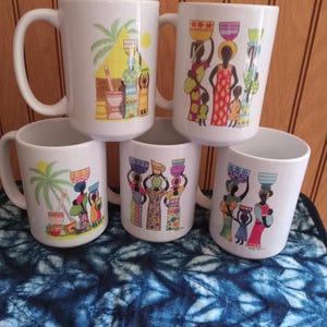 May include: Five white ceramic mugs with colorful illustrations of African women carrying baskets on their heads. The mugs feature different designs, including women near a hut and women in patterned dresses. The mugs have a curved handle.