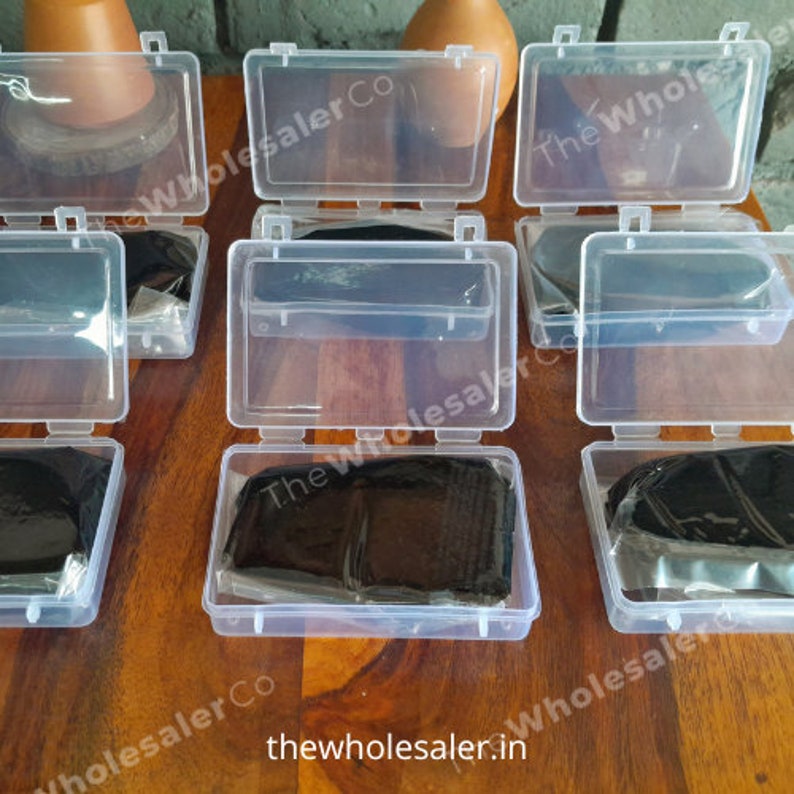 May include: Six clear plastic containers with lids, each containing a black, rectangular object. The containers are arranged in two rows of three. The text "The Wholesaler Co" is visible on the containers.