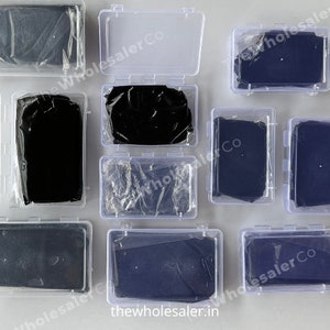 May include: Multiple clear plastic boxes with black fabric squares inside. The boxes are arranged in a grid pattern on a white surface. The text "thewholesaler.in" is visible on the bottom of the image.