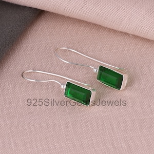 Puede incluir: Un par de pendientes de plata con piedras preciosas rectangulares verdes.