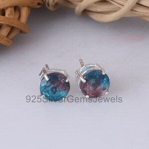 May include: A pair of silver stud earrings with round blue and purple gemstones. 925SilverGemsJewels