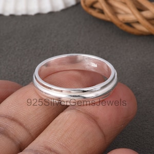 Peut inclure: Une bague en argent avec un design à double couche. La bague est marquée du numéro "926".