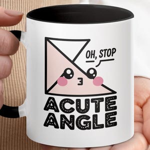 Op de afbeelding: Witte keramische mok met een zwart interieur en handvat. De mok heeft een cartoon ontwerp van een scherpe hoek met de tekst "OH, STOP" en "ACUTE ANGLE". Het ontwerp bevat roze blosjes en zwarte contouren.