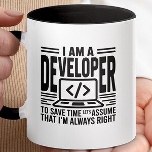 May include: White ceramic mug with a black interior and handle. The mug features the text "I AM A DEVELOPER" above a laptop icon with code symbols, and the phrase "TO SAVE TIME LET'S ASSUME THAT I'M ALWAYS RIGHT."