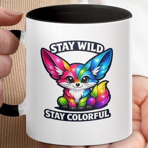 Mug with rainbow fox illustration and text "STAY WILD STAY COLORFUL".