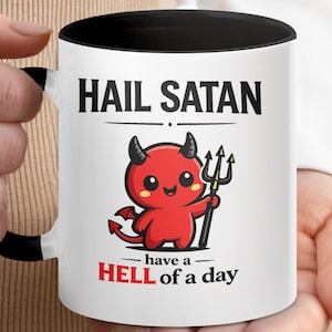 May include: White ceramic mug with a black interior and handle. The mug features the text "HAIL SATAN" above a cartoon devil holding a trident, with the phrase "have a HELL of a day" below.