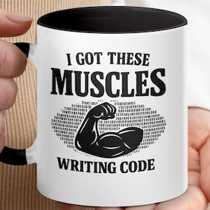May include: White coffee mug with a black interior and handle. The mug features the text "I GOT THESE MUSCLES WRITING CODE" in bold black letters, with a flexed bicep graphic.