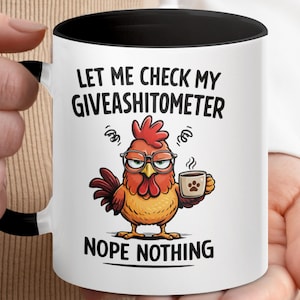 Pode incluir: Caneca de café de cerâmica branca com interior e alça pretos. A caneca apresenta um galo de desenho animado com óculos segurando uma xícara de café. O texto na caneca diz "LET ME CHECK MY GIVEASHITOMETER NOPE NOTHING."