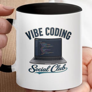 Può includere: Una tazza in ceramica bianca con interno e manico neri. La parte anteriore presenta la grafica di un computer portatile aperto che mostra righe di codice. Sopra il computer, il testo VIBE CODING in blu scuro e sotto, Social Club in blu.