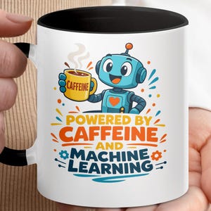 May include: White ceramic mug with a black handle and rim, featuring a cartoon robot holding a coffee cup. The mug has the text "POWERED BY CAFFEINE AND MACHINE LEARNING" in orange, blue, and yellow.