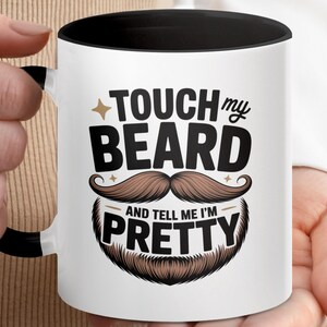 Może przedstawiać: Biały ceramiczny kubek z czarnym wnętrzem i uchwytem, z napisem "TOUCH my BEARD and TELL me I'M PRETTY" w kolorze czarnym i brązowym. Projekt zawiera stylizowane wąsy i brodę.