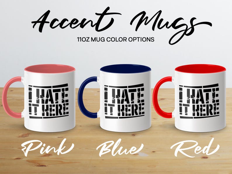 Three 11oz mugs with "I Hate It Here" text, in pink, blue, and red.